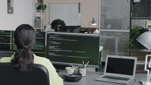 Female Software Engineer Coding on Desktop Computer in Office