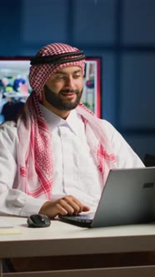 Man Waving During Video Call at Desk