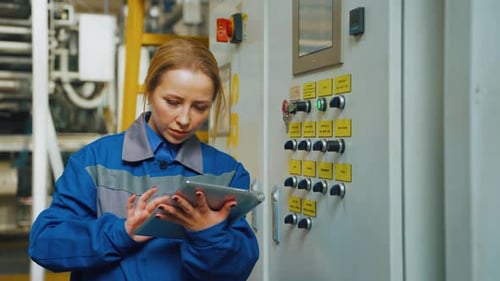 Technician Engineer Woman in Production Workshop of a Modern Factory Adjusts Equipment Machine