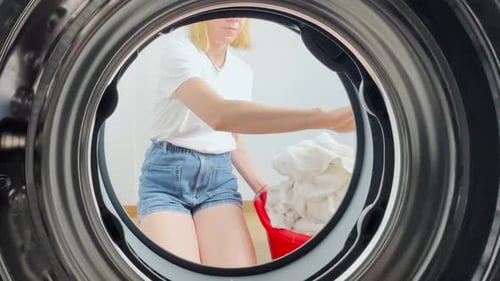Point of View From Inside a Washing Machine As a Young Woman in Casual Clothes Loads Laundry Modern