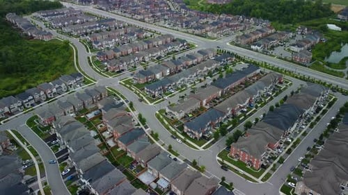 Aerial view of suburban neighborhood, flying forward and panning down at houses