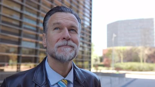 Gray-Haired Man Outdoors Near Modern Building