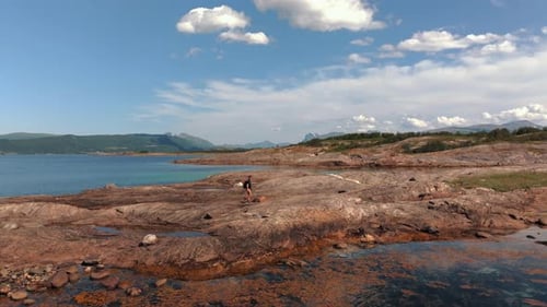 Volcanic Rocky Norway Bathed in Sunlight a Traveler Walks the Stone