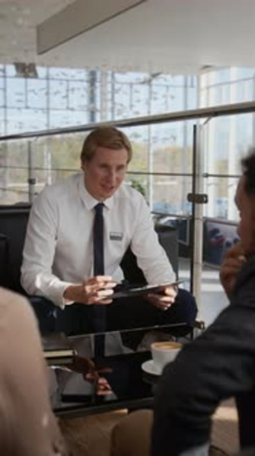Salesman Handing Document to Client in Car Dealership