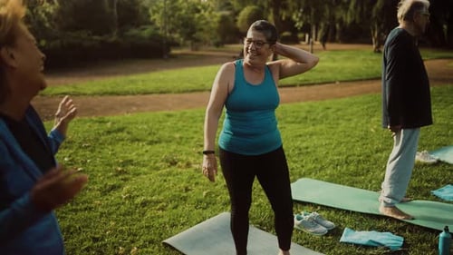 Happy senior friends having fun doing workout activity in a public park