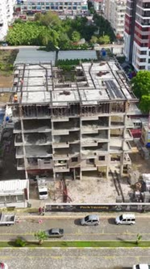 Los ingenieros de vídeo vertical supervisan mientras los trabajadores preparan estructuras de acero y bases de piedra para el hormigón