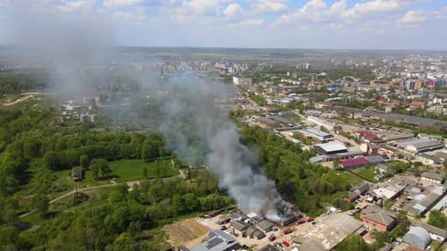 Vue aérienne des pompiers éteignant un bâtiment en ruine en feu dont le toit s'est effondré et s'élève