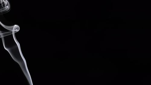 Wispy smoke rising against a dark background