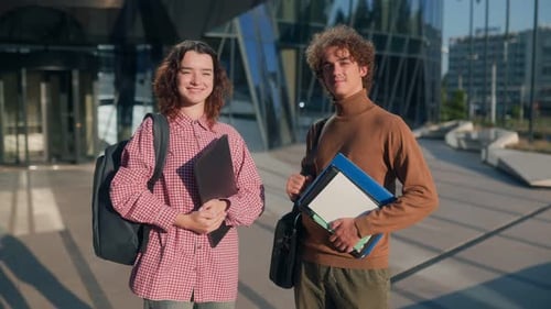 Portrait of Two College Students Standing in Front of Modern Glass Campus