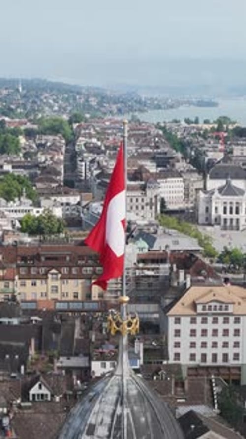 Aerial video of the Swiss flag at the Grossmunster church and the city in the background.