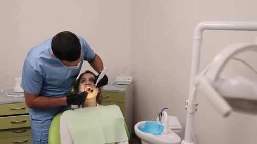 Dentist Performing Procedure on a Patient in Office