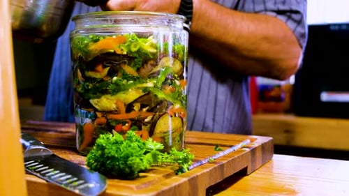 Pickling liquid added to vegetables layered in glass jar