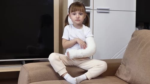 Child With Arm Cast Sitting on Couch