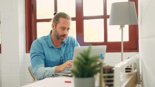 Man Working Remotely on Laptop in Home Office