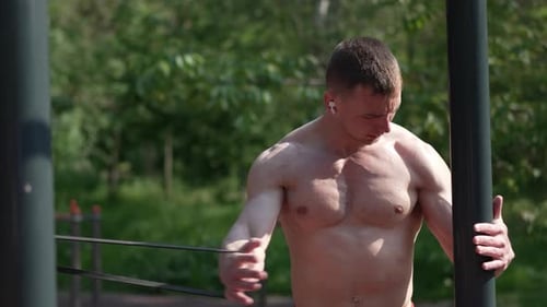 Muscular Man Strength Training Outdoors with Resistance Bands