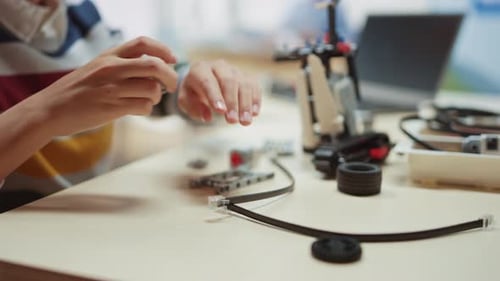 Intelligenter Schüler baut/konstruiert einen kleinen Roboter und programmiert mit dem Laptop Software für Robotik En