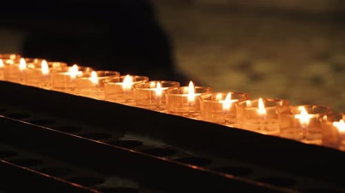 Candles illuminate the interior of church, creating a serene atmosphere with warm.
