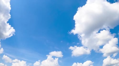 Strahlender Sommerhimmel mit weißen, weichen Wolken. Die Sonne beleuchtet die wunderschöne Wolkenlandschaft. Niedriger Blickwinkel.