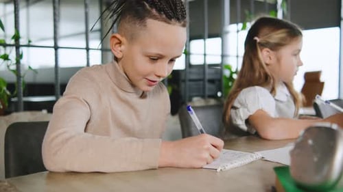 Schoolchildren are Writing Notes at a School Activity in a Classroom Setting During the Daytime with