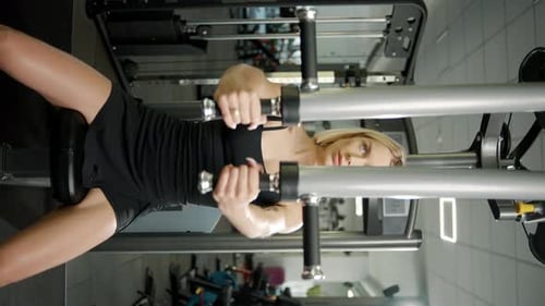 Beautiful sport girl engaged on a simulator in the gym