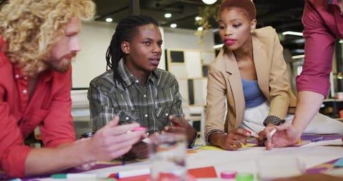Happy diverse business people discussing work during meeting at office
