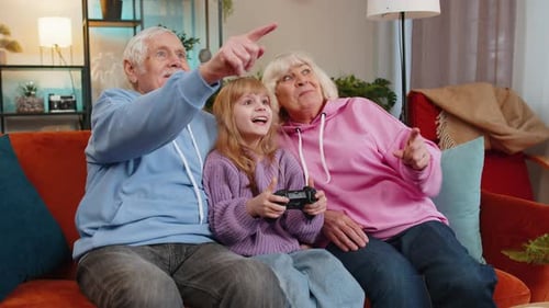 Girl Plays Video Game with Cheering Grandparents