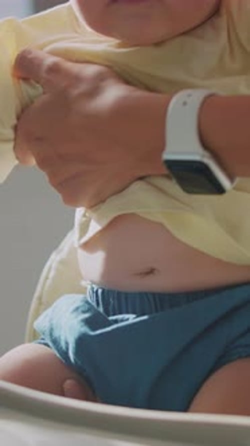 Adorable baby sits in high chair looking around