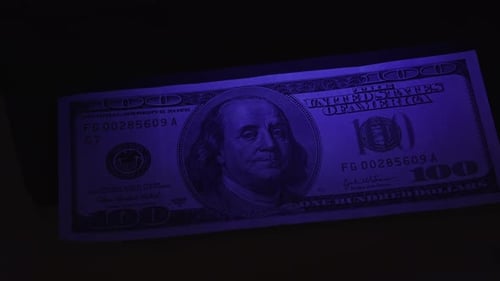 Examining One Hundred Dollar Bills Under UV Light