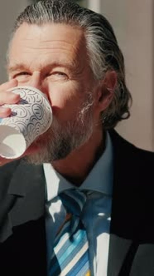 Vertical video, Businessman Enjoys Coffee Break Outside Office