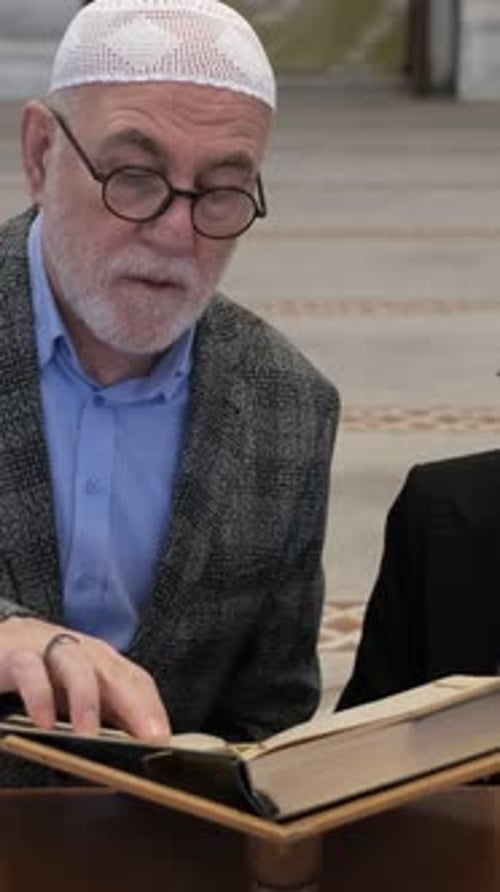 Senior Man Reads Religious Text in Mosque