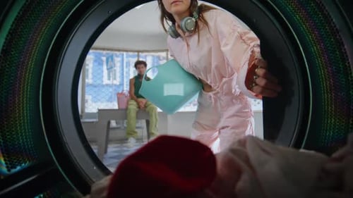 Young Woman Loads Laundry into Washing Machine