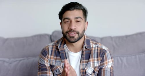 Man Speaking Directly to Camera on Couch