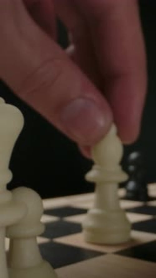 Hand Moving Game Pieces on Chessboard Close Up