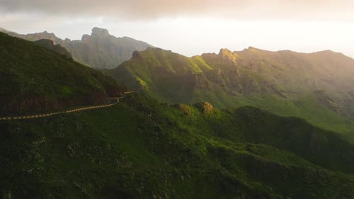 Modern Narrow Paved Winding Mountain Road Against the Background of Hills and Green Rocky Ridges