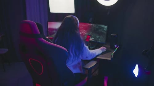Back View of Woman Playing Video Game in LED Lit Room