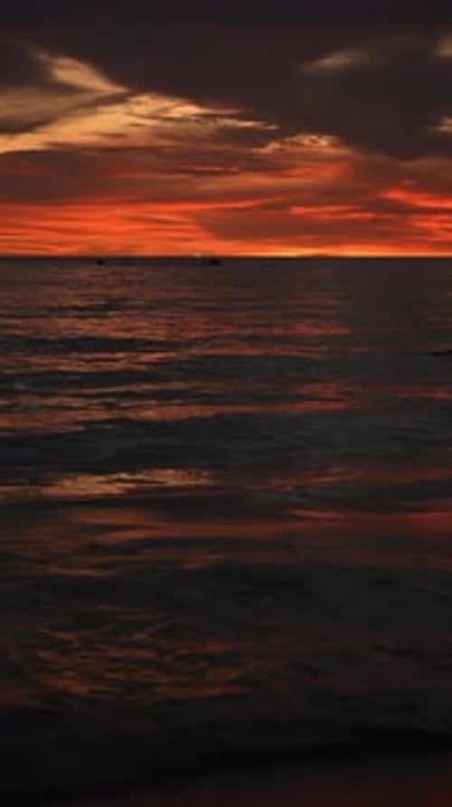 Vivid and Serene Evening Sky Reflected on Calm Ocean Waters Amidst the Warm Glow of a Striking