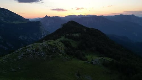 A Drone Flies Over a Picturesque Mountain Range During the Golden Hour at Sunset
