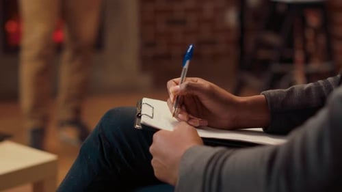 Psychothérapeute prenant des notes sur des articles et écoutant l'homme