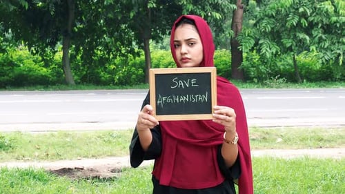 Woman holds sign with 'Save Afghanistan' Message
