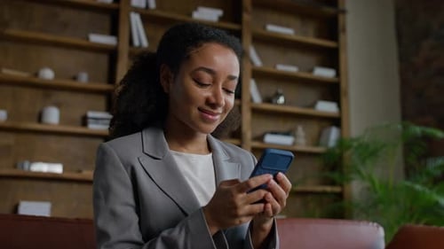 Businesswoman Typing Message on Smartphone in Office