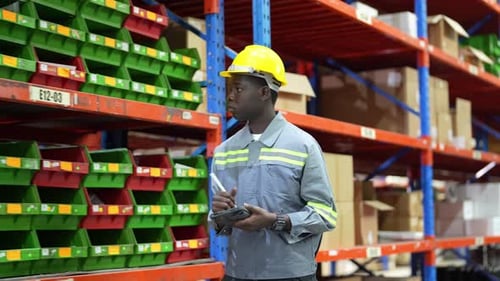 Warehouse Industrial and Logistics Companies. Dispatcher in uniform making inventory in storehouse.