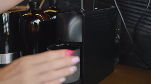 Woman Making Coffee in Kitchen With Machine