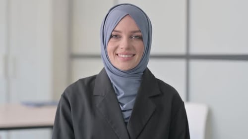 Porträt einer lächelnden muslimischen Geschäftsfrau, die in die Kamera schaut