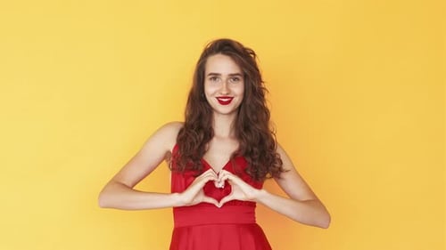 Smiling Woman Making Heart Shape with Hands
