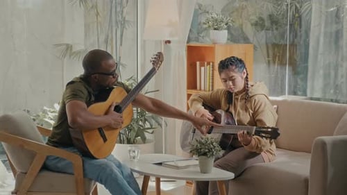 Man and Woman Playing Guitars Indoors Together