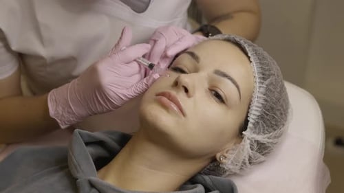 Woman Receiving Cosmetic Injection Treatment on Face