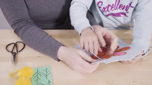 Little Girl Learning How to Sew with Her Mother at the Craft Table