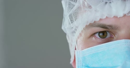 Portrait d'un médecin ou d'un chirurgien portant un masque médical, un respirateur, des yeux bruns, une casquette chirurgicale, dans