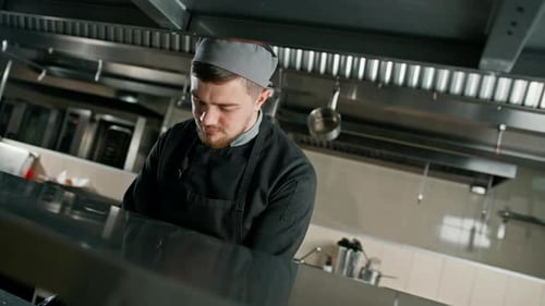 Professional kitchen in the restaurant of the hotel the chef stands thoughtfully and looks down