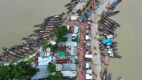 Aerial view of boats and houses near riverbank, Bangladesh.